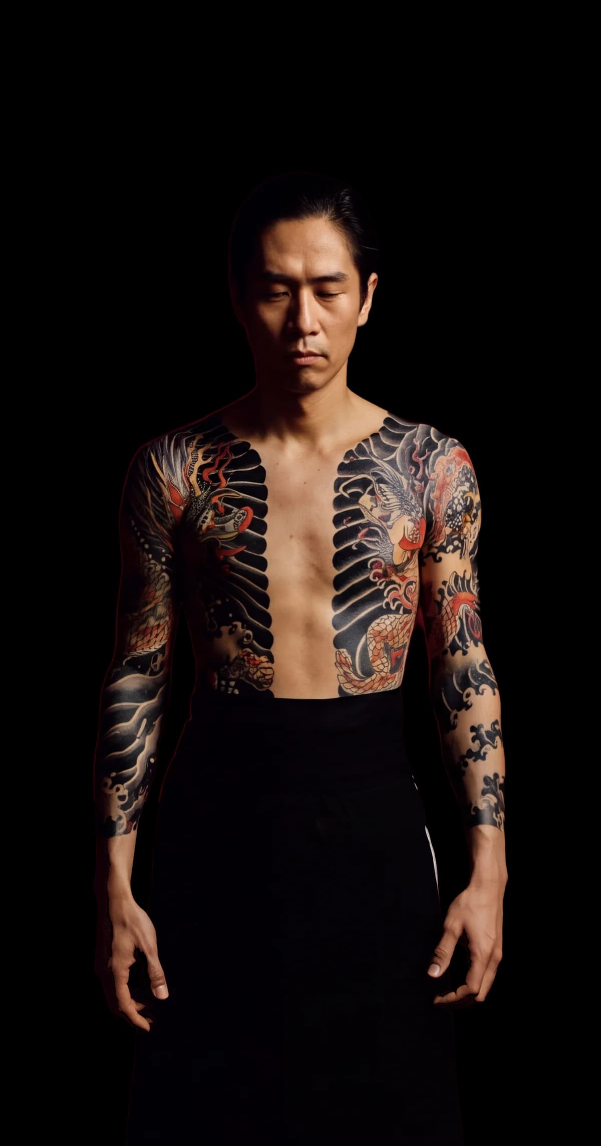 A man in a traditional Japanese body suit stands with his eyes closed in dark water and ink.